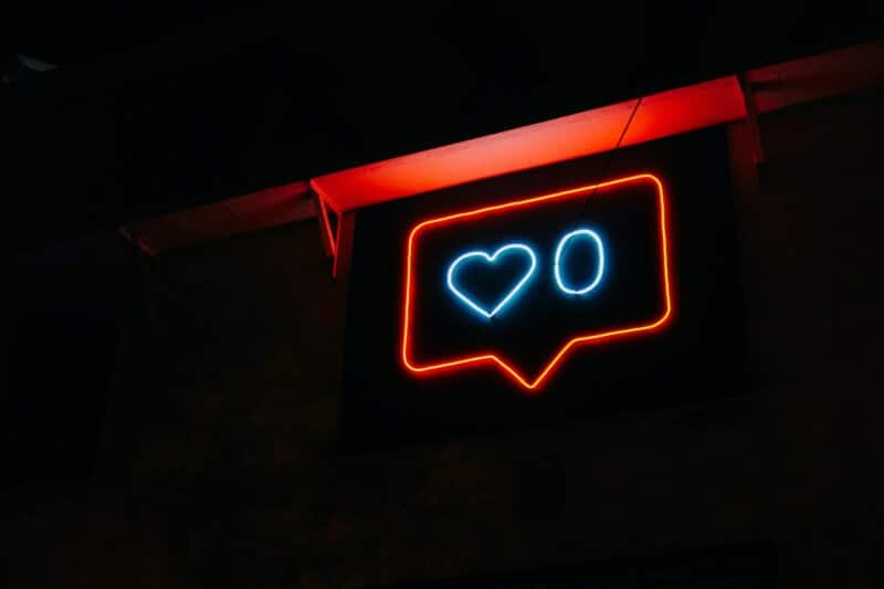 Bright neon heart icon with zero likes, symbolizing social media engagement.