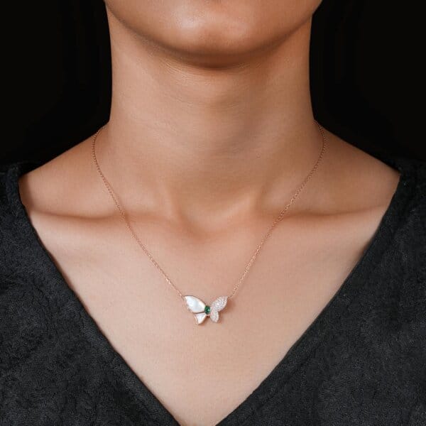 A close-up of an elegant butterfly pendant necklace captured on a model's neck, showcasing its fine jewelry design.